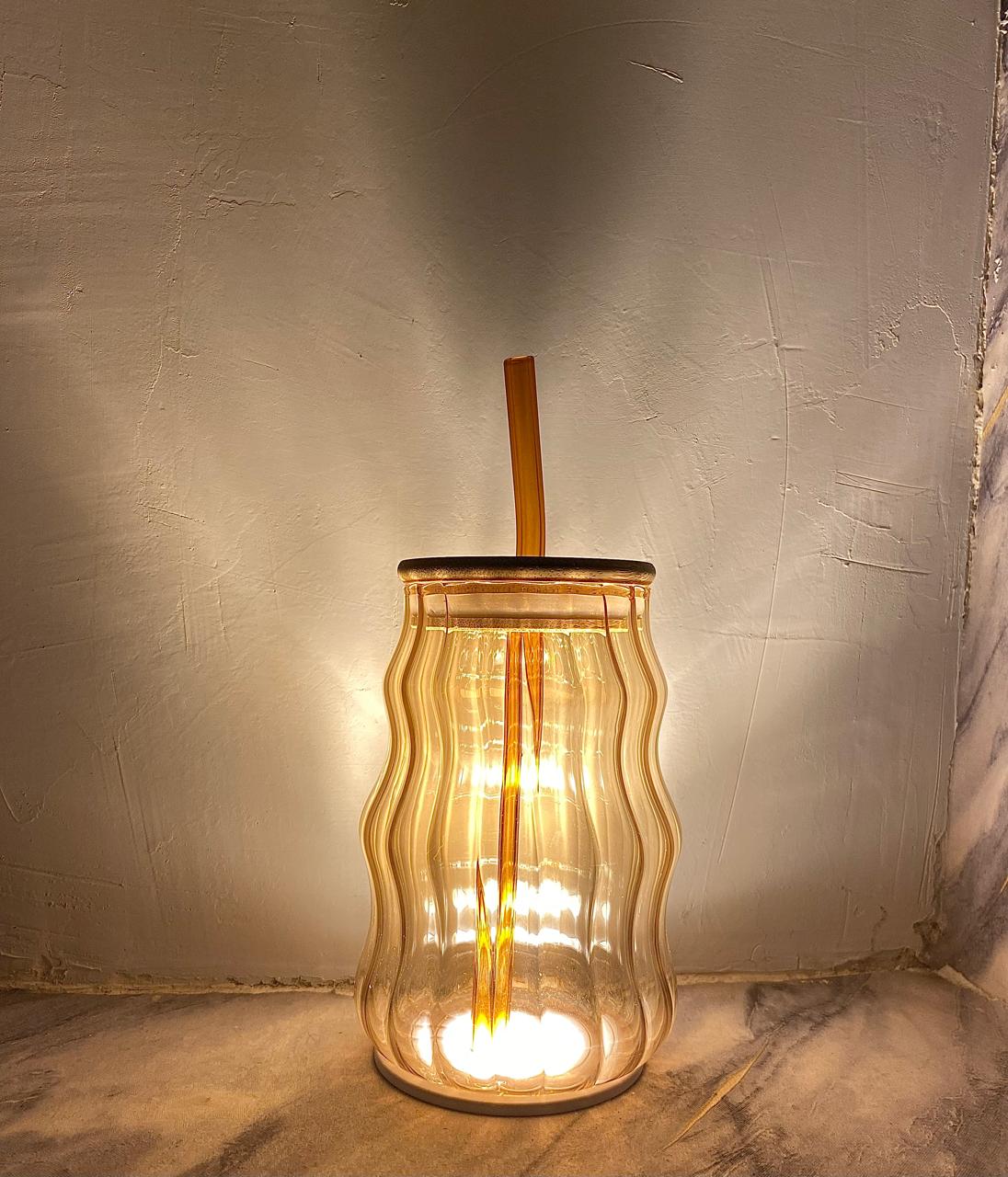 Amber wave glass tumbler with bamboo lid and straw.